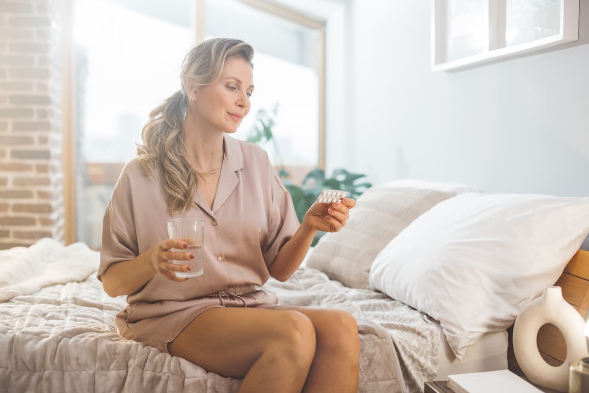 Une femme qui regarde ses gélules pour la contraception