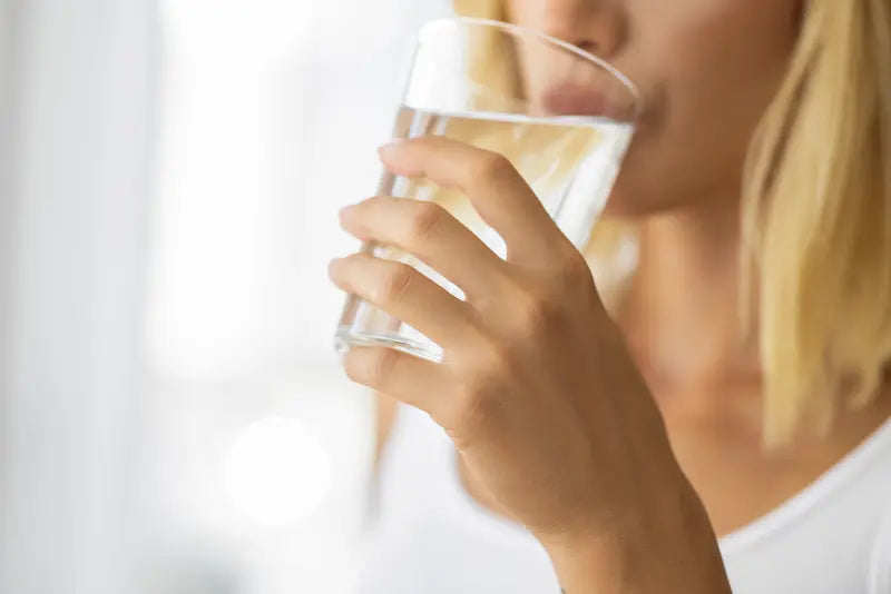 Une femme qui boit un verre d'eau