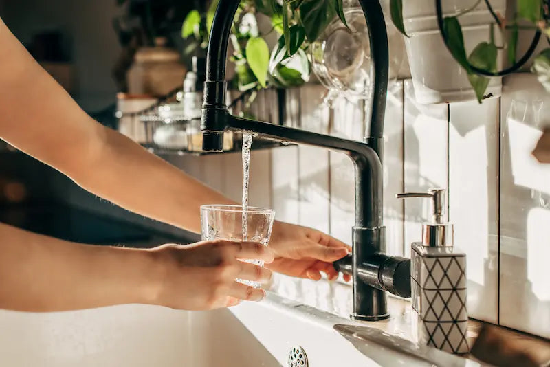 Femme qui se serre un verre d'eau