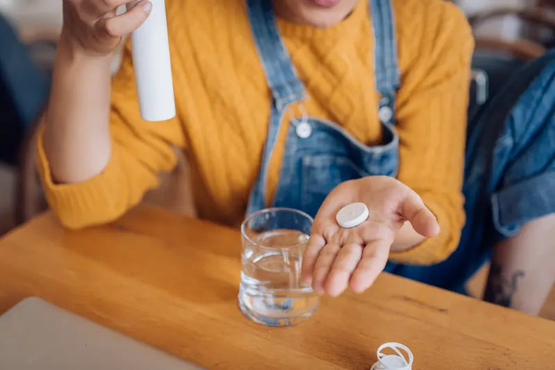 Une personne qui va prendre un complément alimentaire pour l'hydratation
