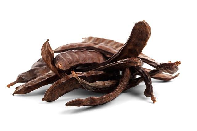 Fruits de caroube bruns, alternative naturelle au chocolat.